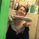 Somebody walks in on a girl wearing glasses while she is taking a shit on the toilet. She grunts and makes a wet gurgling sound while pooping. Foreign language spoken.